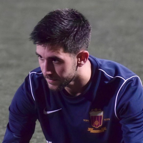 Alejandro Castillo estirando sobre el césped después de un partido, con la equipación de su club.